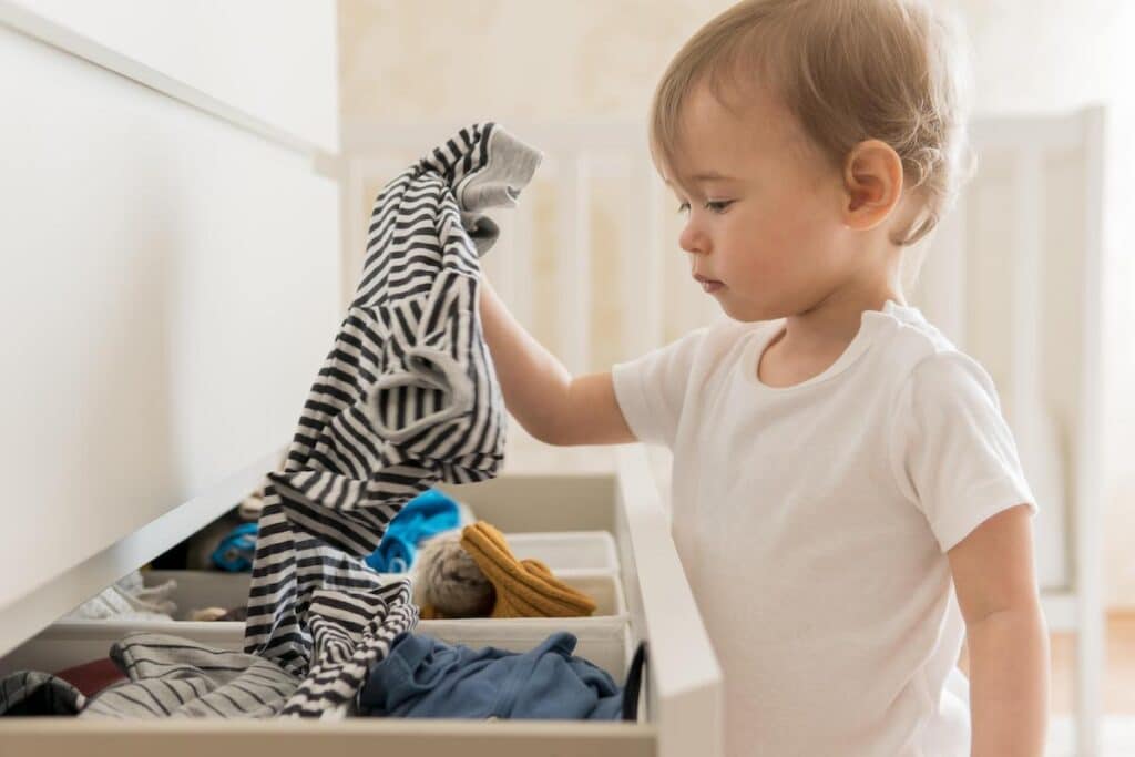 phrases to use when your toddler doesn't listen - Toddler picking clothes
