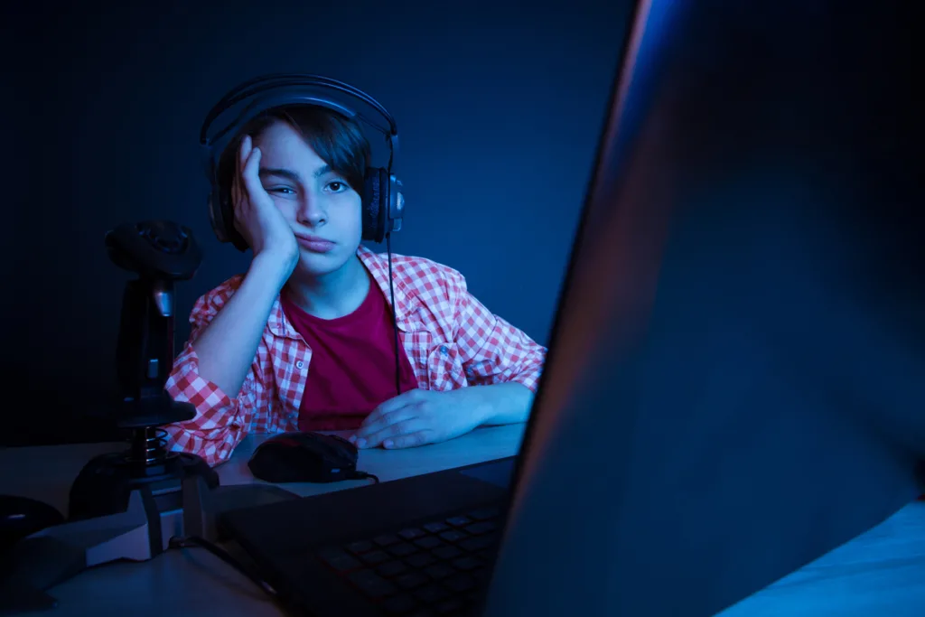 Boy immersed in the laptop screen while playing video games