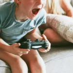 Tense boy yelling holding a video game controller