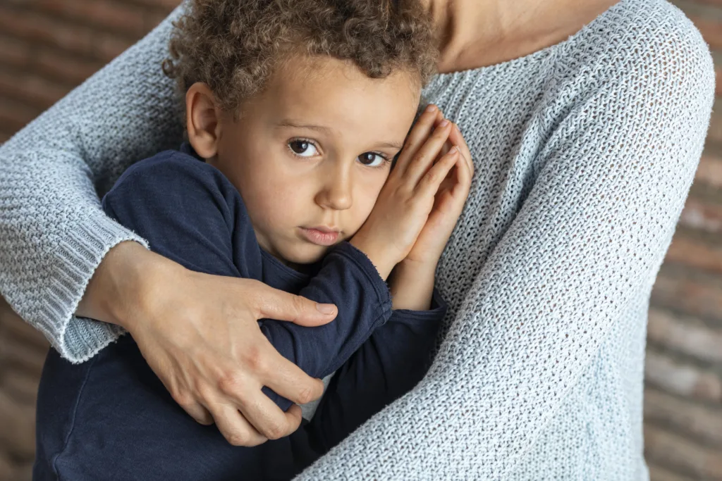 Boy being comforted in his mother’s arms