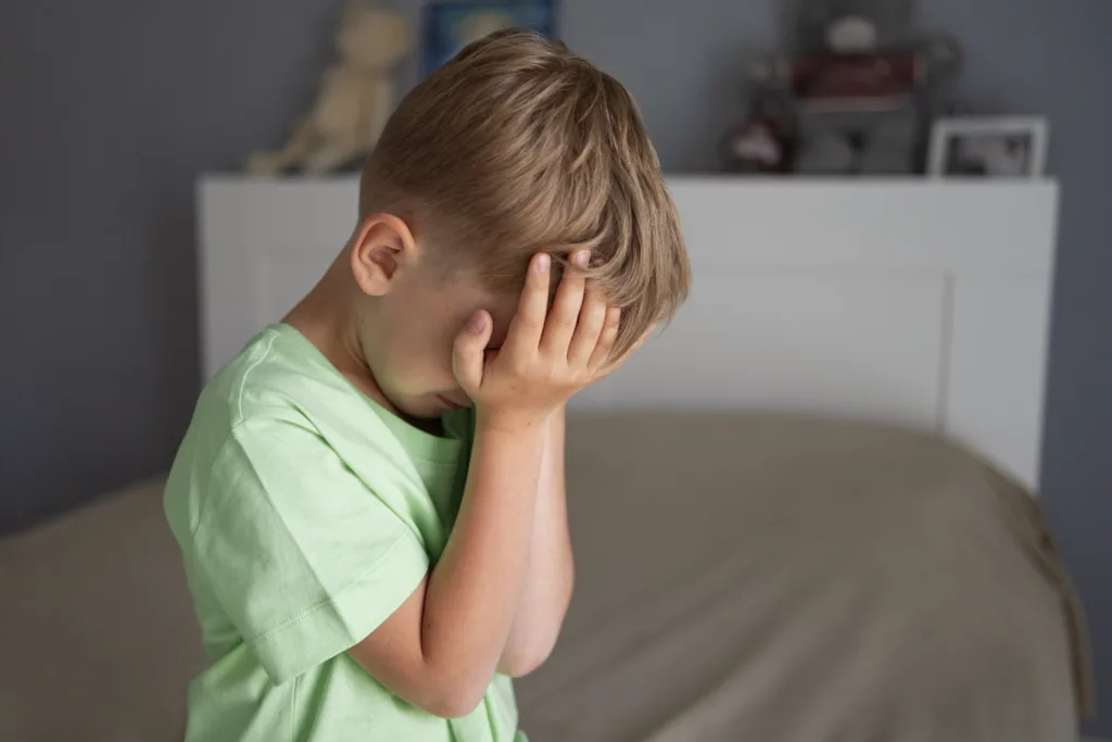 anger management for kids - little boy in his room covering his face with his palms