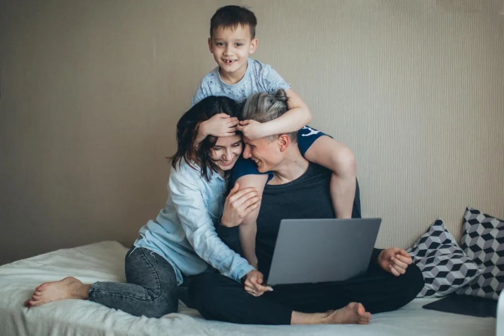 mom, dad and kid in front of laptop attending online parenting classes