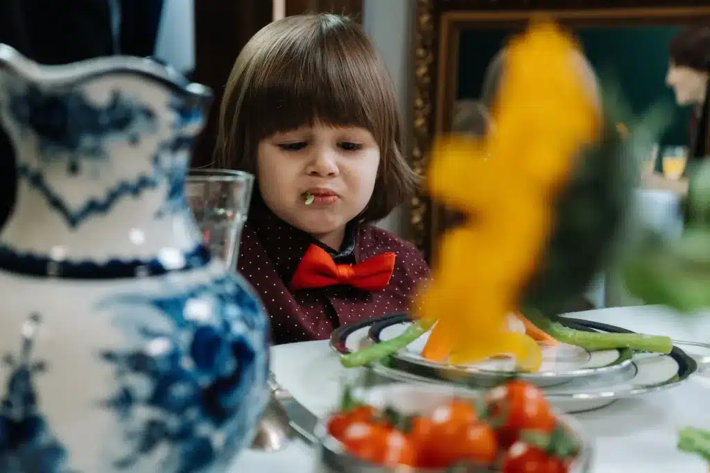 upset little boy eating vegetabes