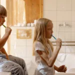 kids brushing teeth togethers, in front of the mirror