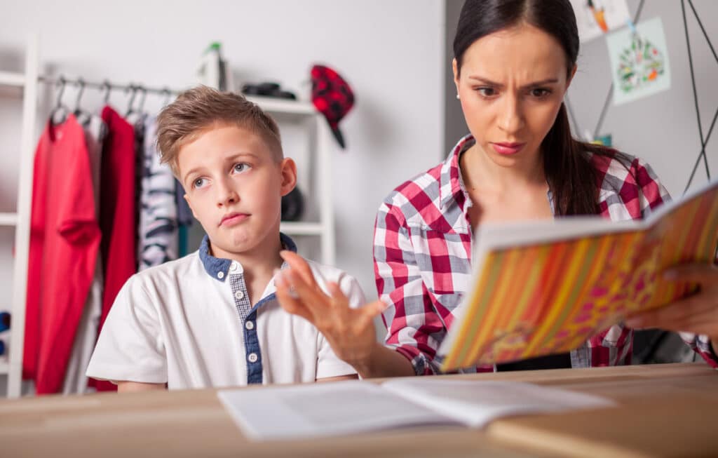 Discontent mom checking her middle school son’s homework 