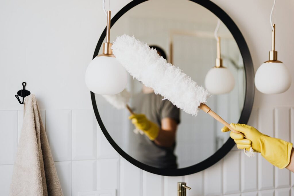 Duster brush cleaning bathroom mirror