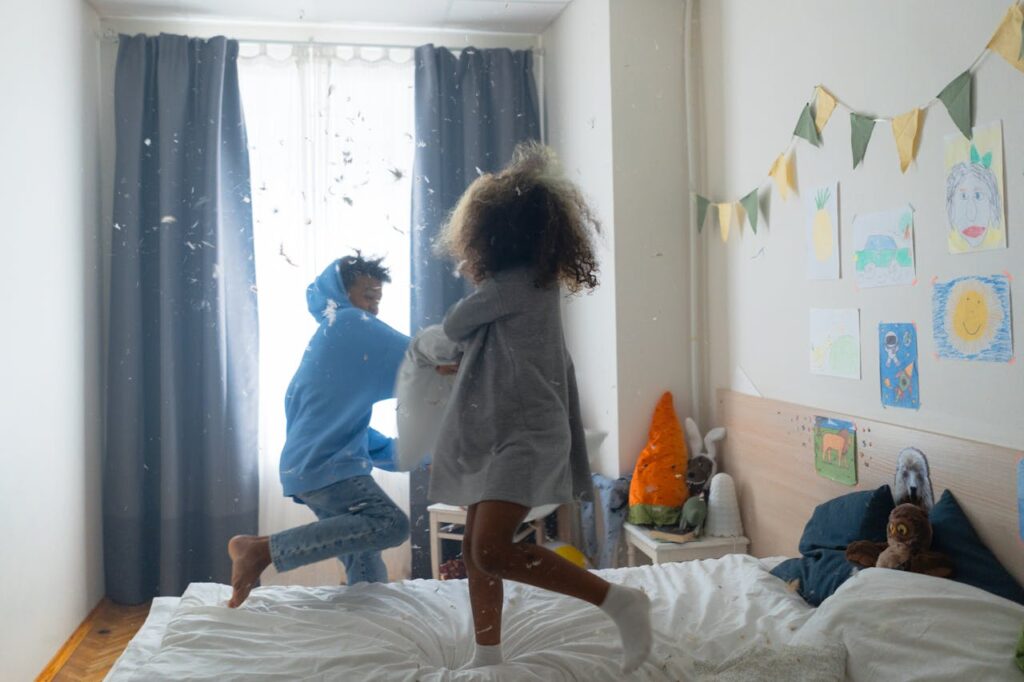 pillow fight in bed, between brother and sister