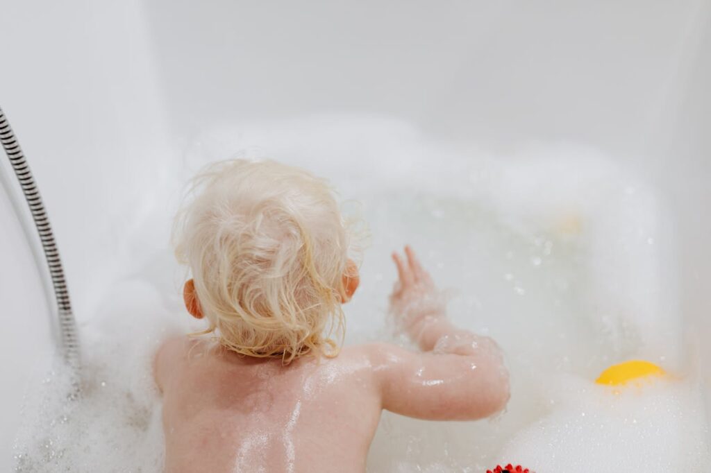 toddler in a bathtub filled with foam bubbles