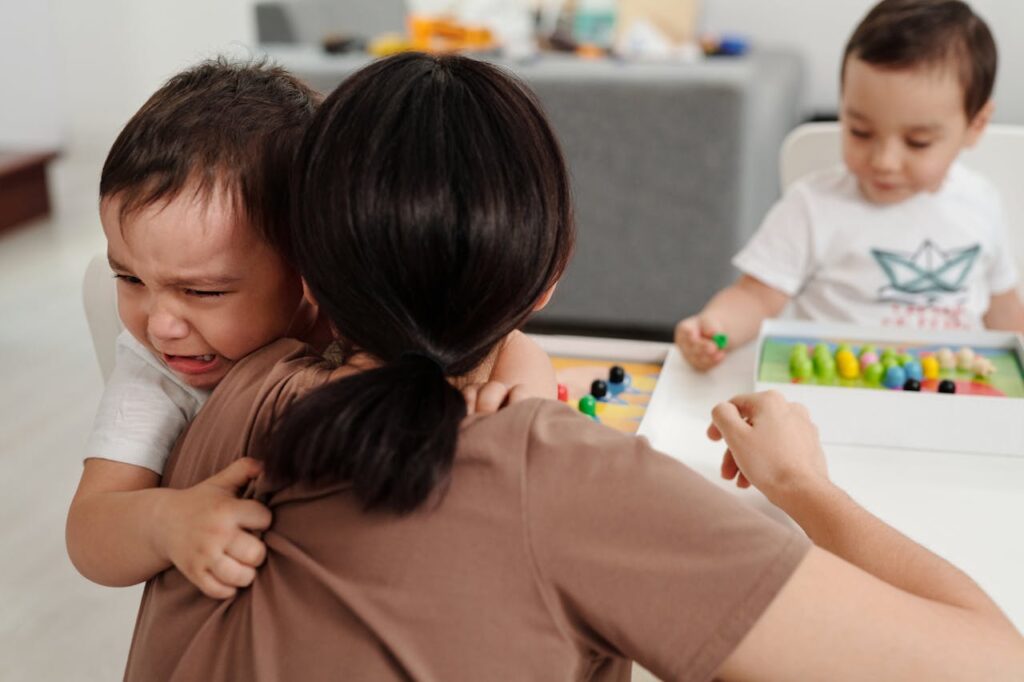 Child yelling and crying in mother's arms.