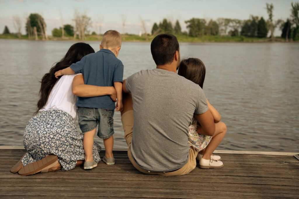 Mom and dad spend time with their two kids by the lake.